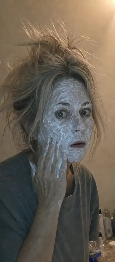 Woman applying a face mask at home